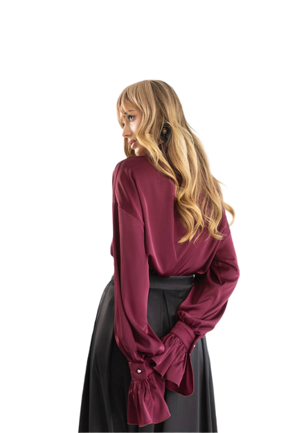 Person wearing a burgundy blouse and black skirt on a white background