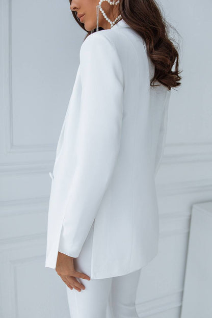 Person wearing a white suit against a light gray background