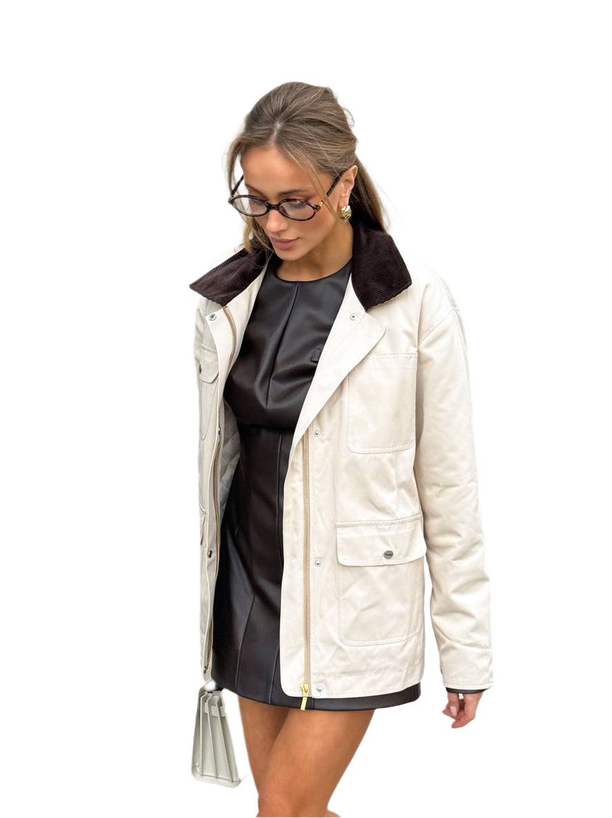 Woman wearing a white jacket with a black collar on a white background