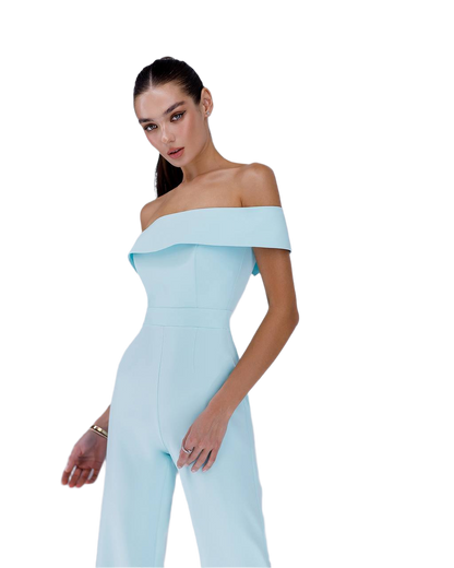 Woman wearing a light blue off-shoulder jumpsuit on a white background