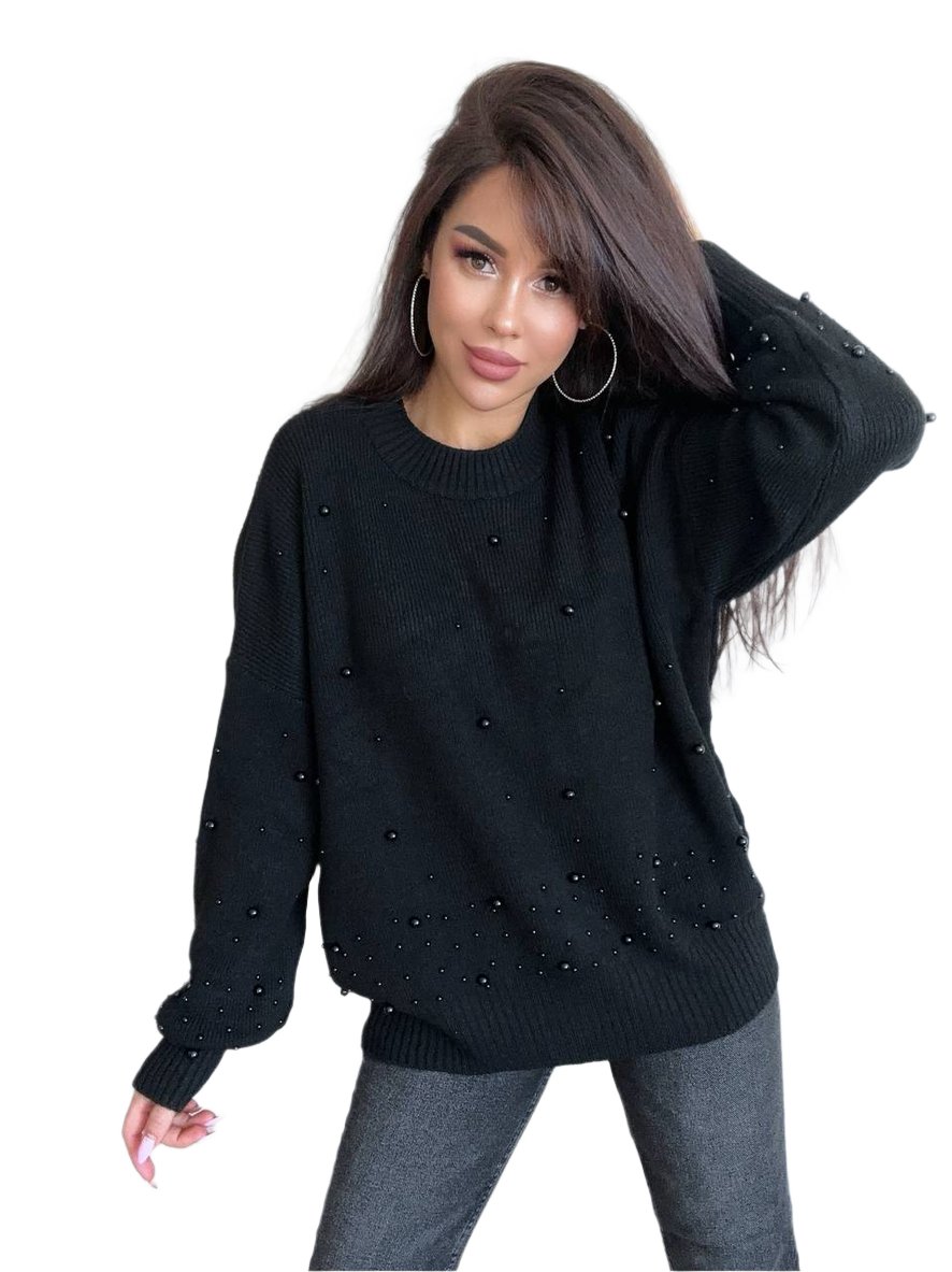 Woman wearing a black sweater with pearl embellishments on a white background