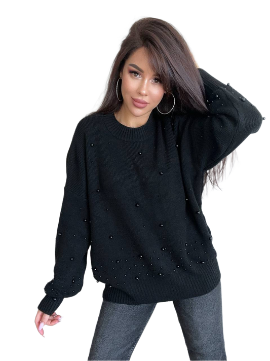 Woman wearing a black sweater with pearl embellishments on a white background