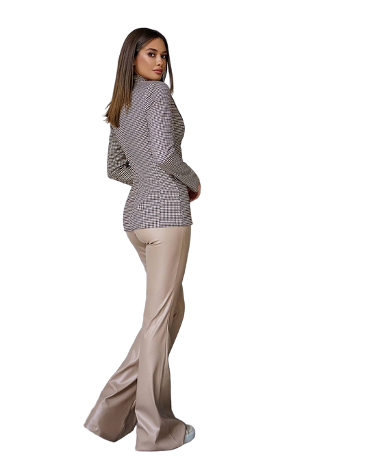 Woman wearing a checkered blazer and beige pants on a white background