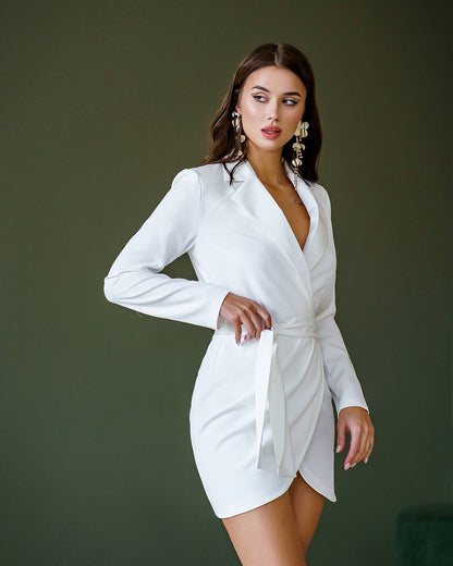 Woman wearing a white blazer dress against a dark background