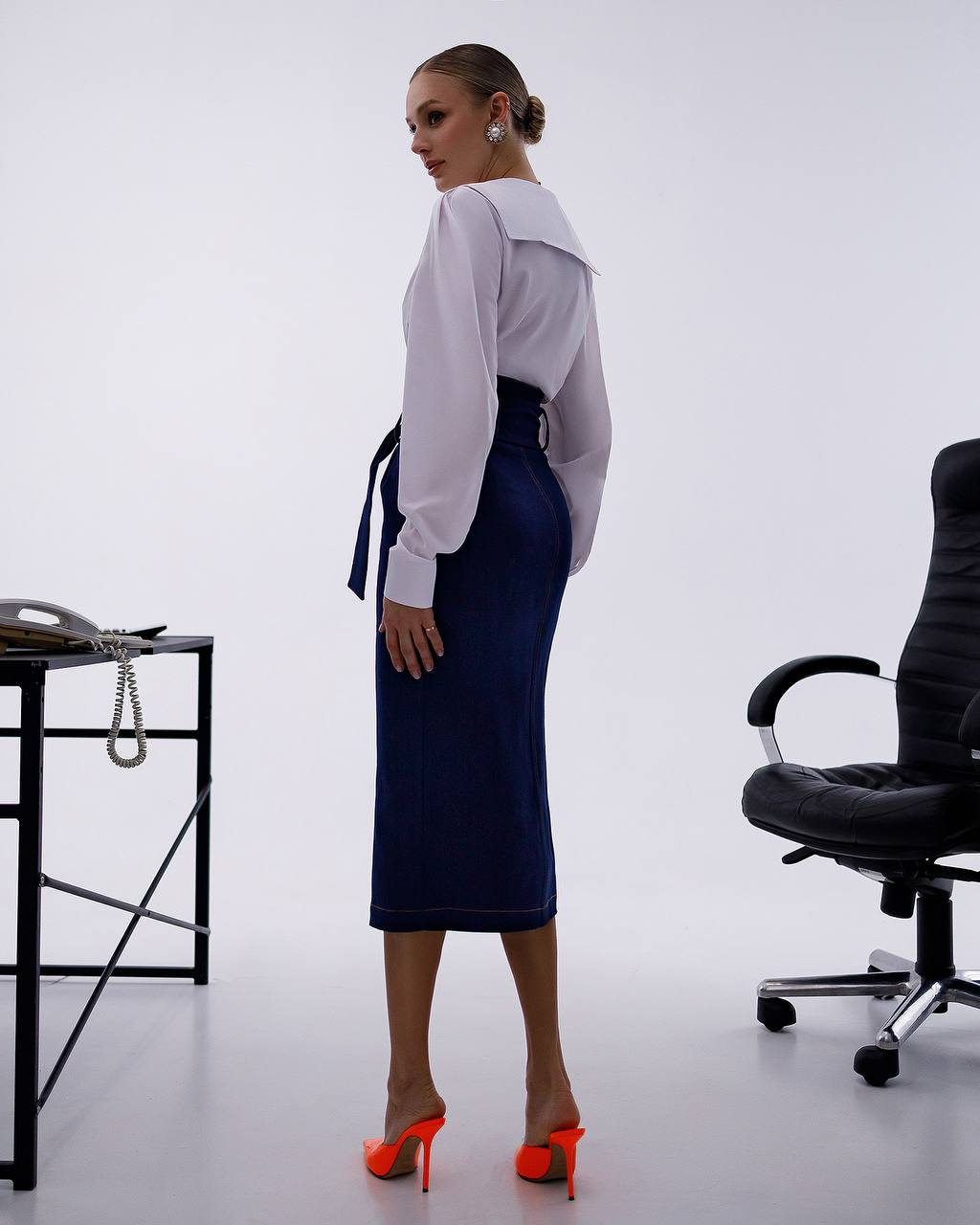 Woman in a professional setting with a desk and chair in the background