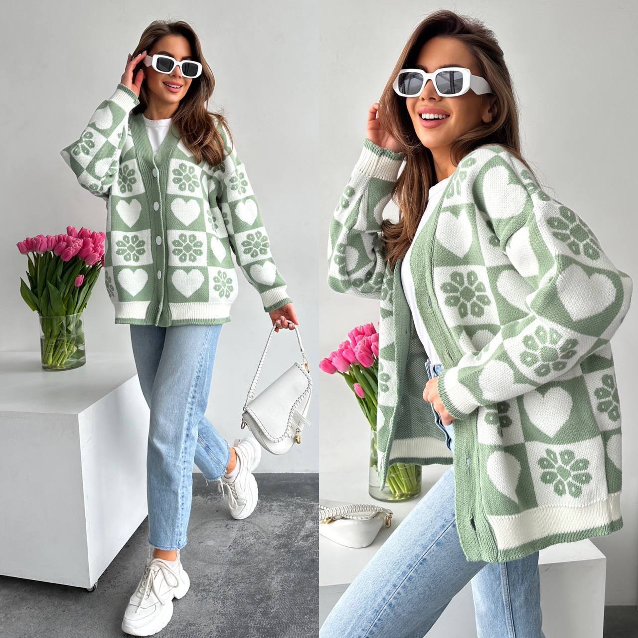 Woman wearing a green patterned cardigan with a vase of pink tulips in the background