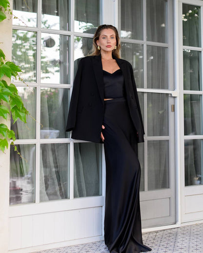 Woman in a black outfit standing in front of a glass door.