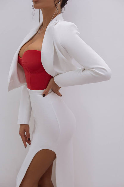 Person wearing a white blazer over a red top on a plain background
