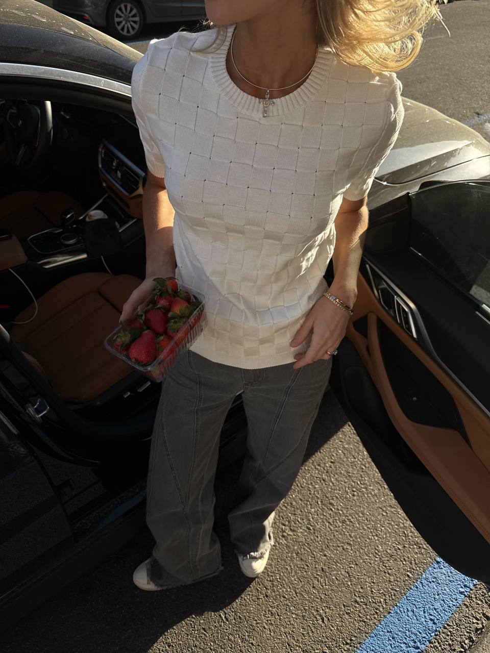 Person holding strawberries next to an open car door