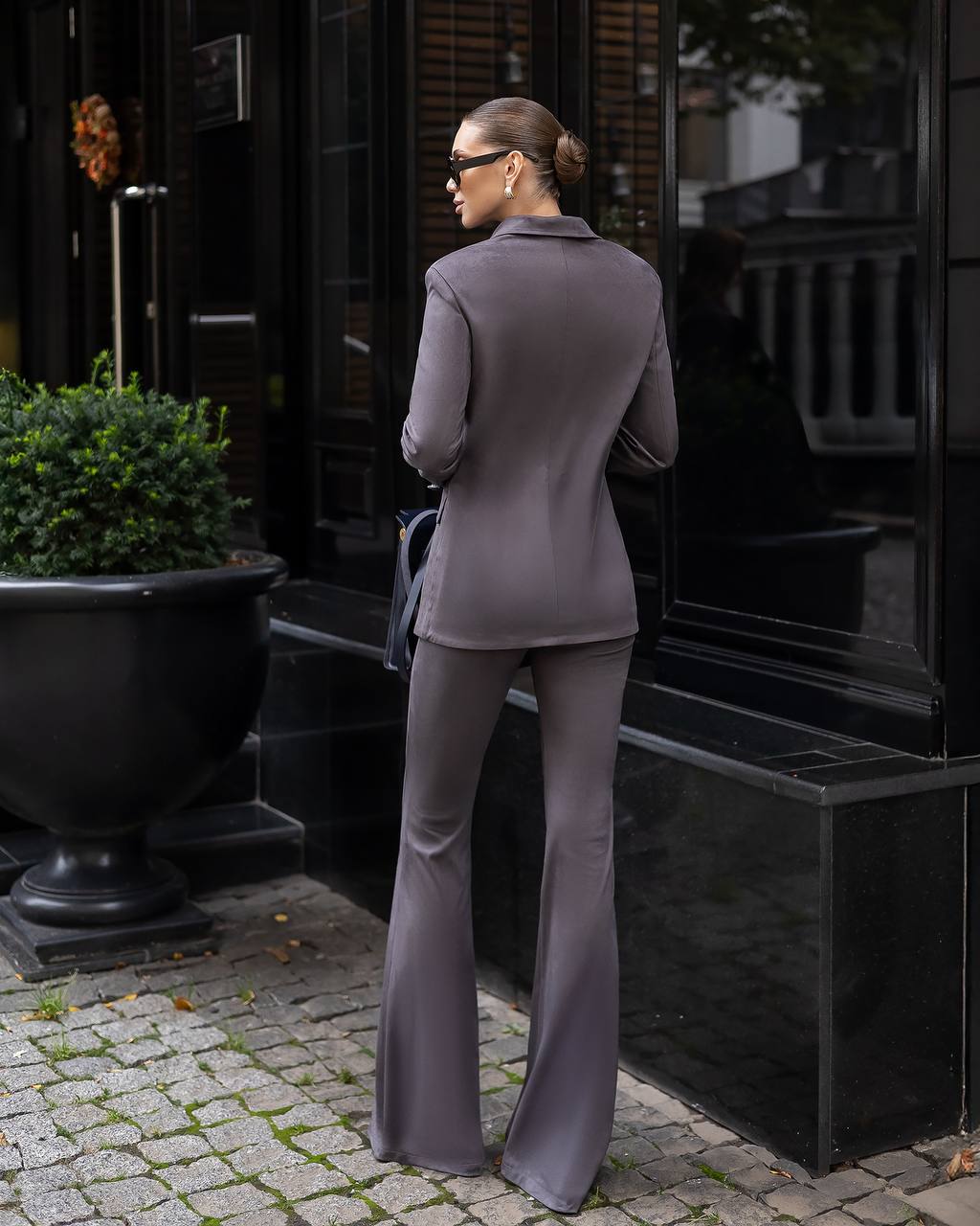 Woman in a gray suit standing outside a building