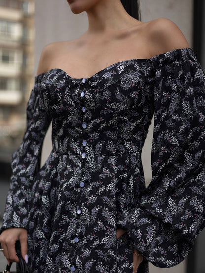 Black floral off-shoulder dress with long sleeves on a blurred background