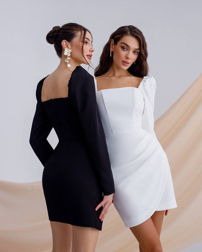 Two women wearing black and white dresses against a neutral background