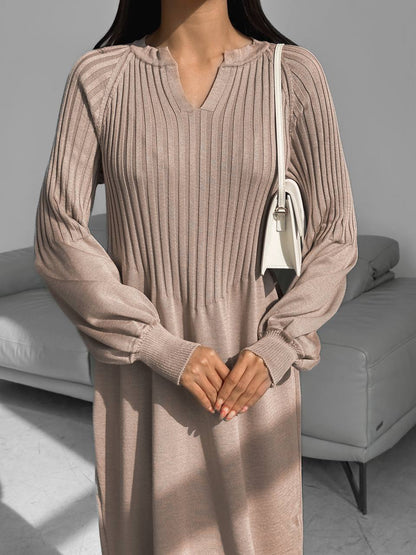 Woman wearing a long ribbed dress in a neutral setting
