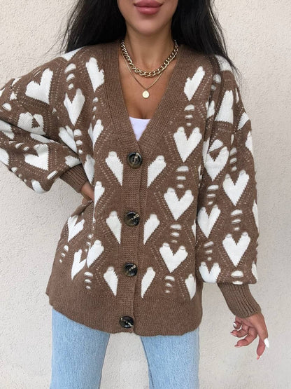 Person wearing a brown cardigan with white pattern against a plain background