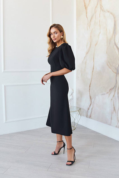 Woman wearing a black dress in a stylish interior setting