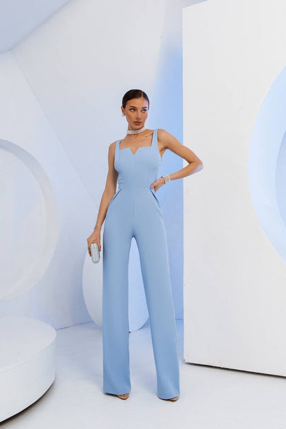 Woman wearing a light blue jumpsuit in a minimalistic setting