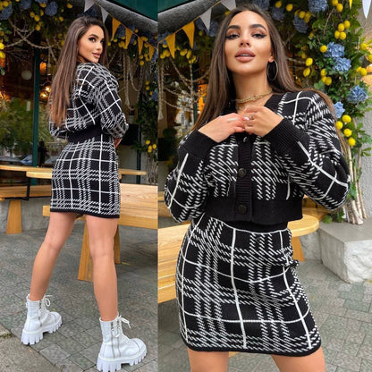 Woman wearing a black and white checkered outfit with a sweater and skirt, standing outdoors.