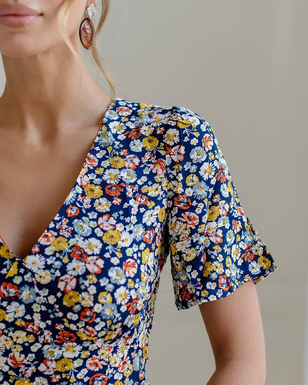 Woman wearing a floral dress with a neutral background