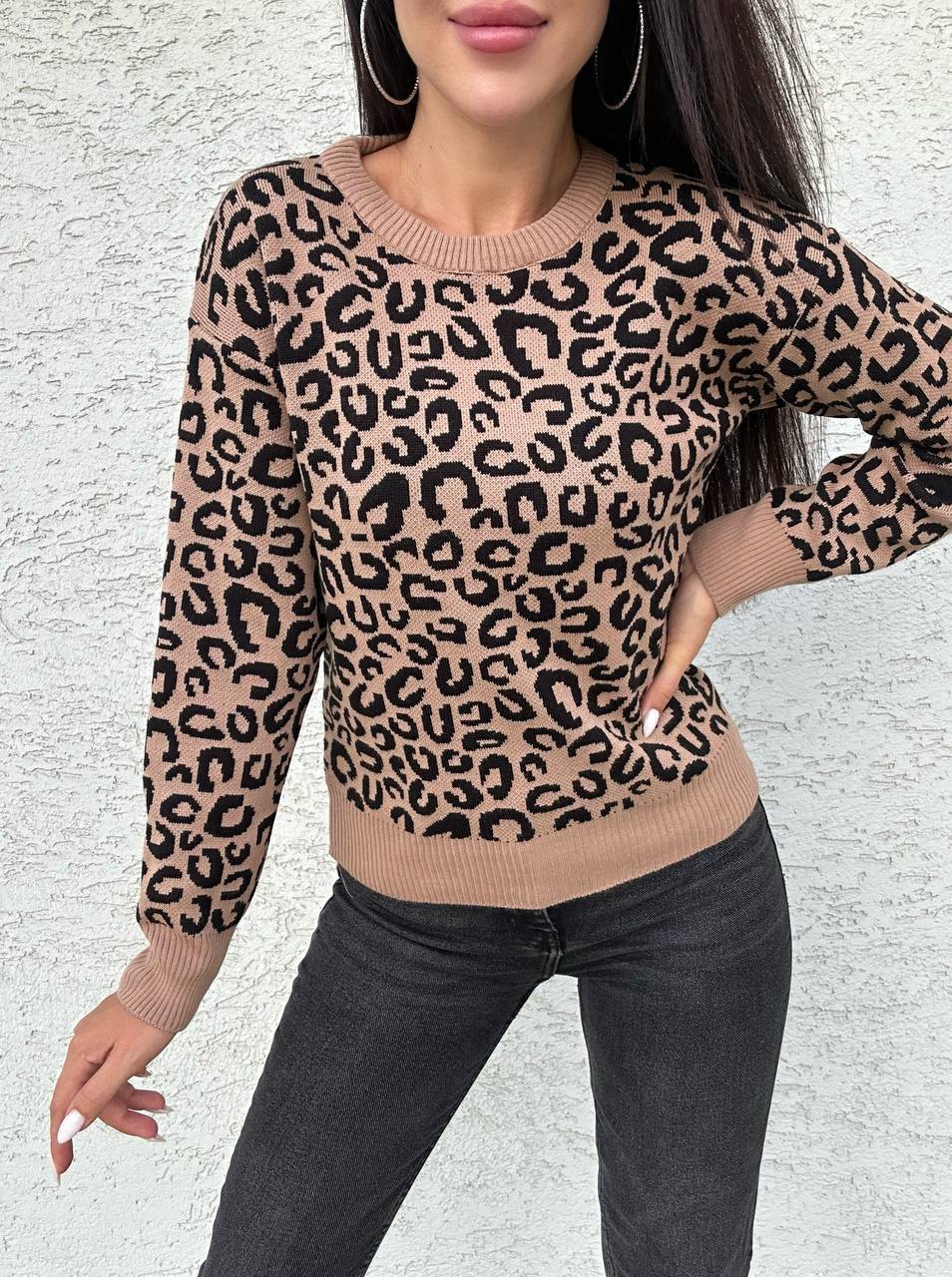 Person wearing a leopard print sweater against a light background