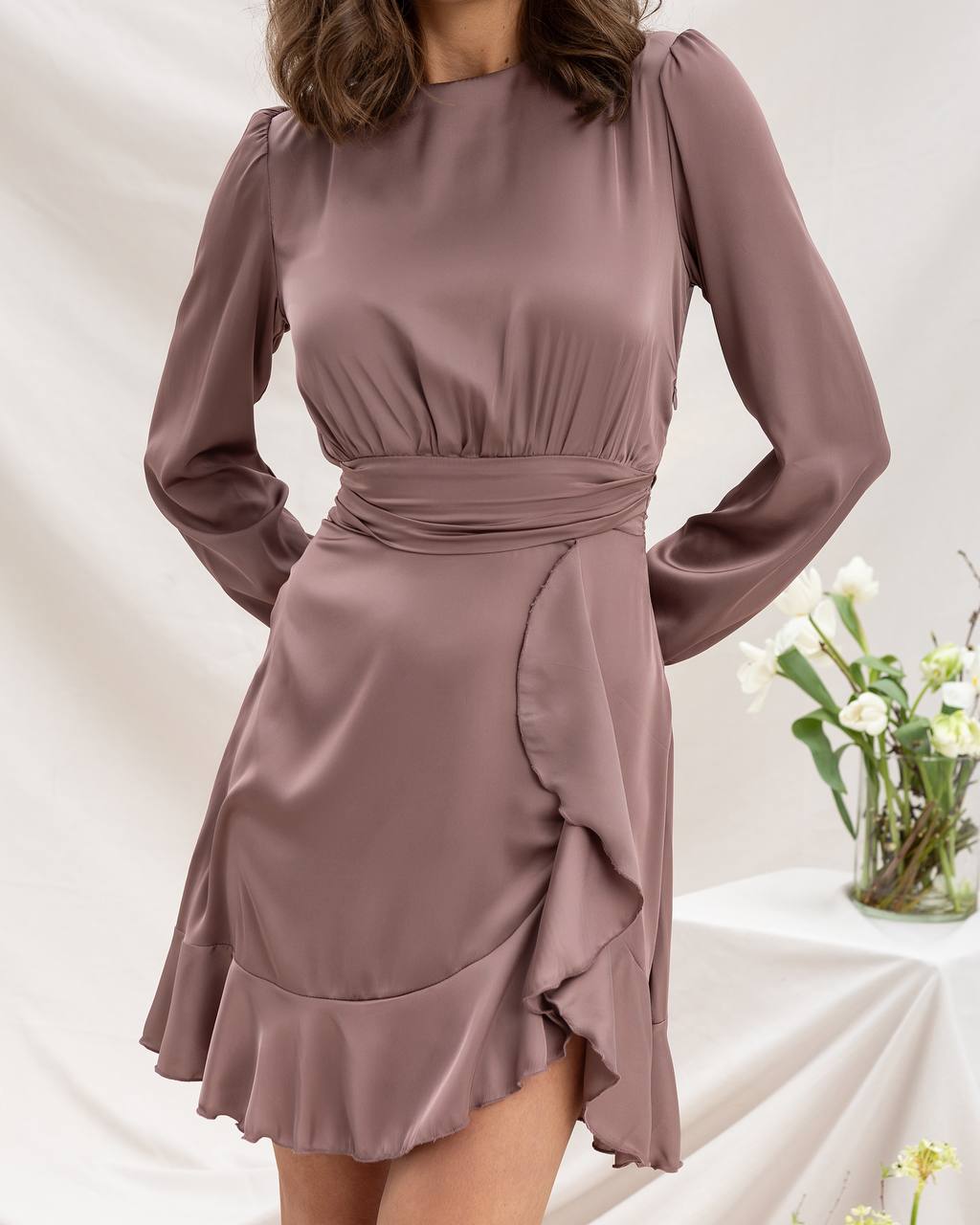 Mauve dress with long sleeves on a neutral background