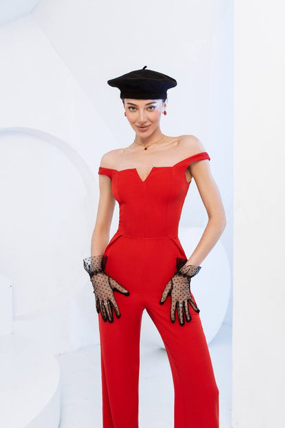Woman wearing a red jumpsuit with a black beret and gloves on a white background