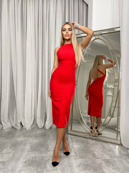 Woman in a red dress standing in front of a mirror in a room with white curtains.