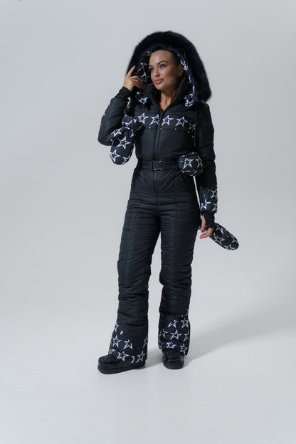 Person wearing a black snowsuit with star patterns on a white background