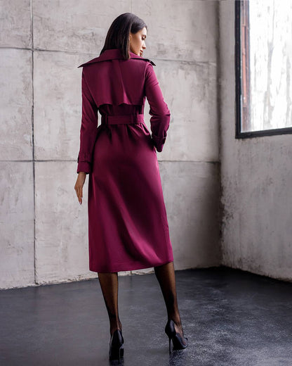 Woman wearing a burgundy trench coat in an urban setting