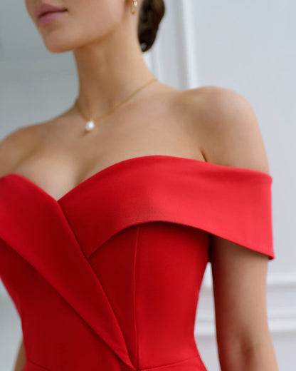 Red off-shoulder dress worn by a person with a blurred background