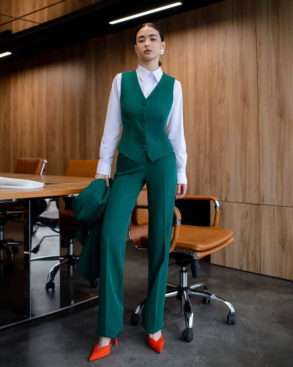 Woman in a green suit standing in an office setting