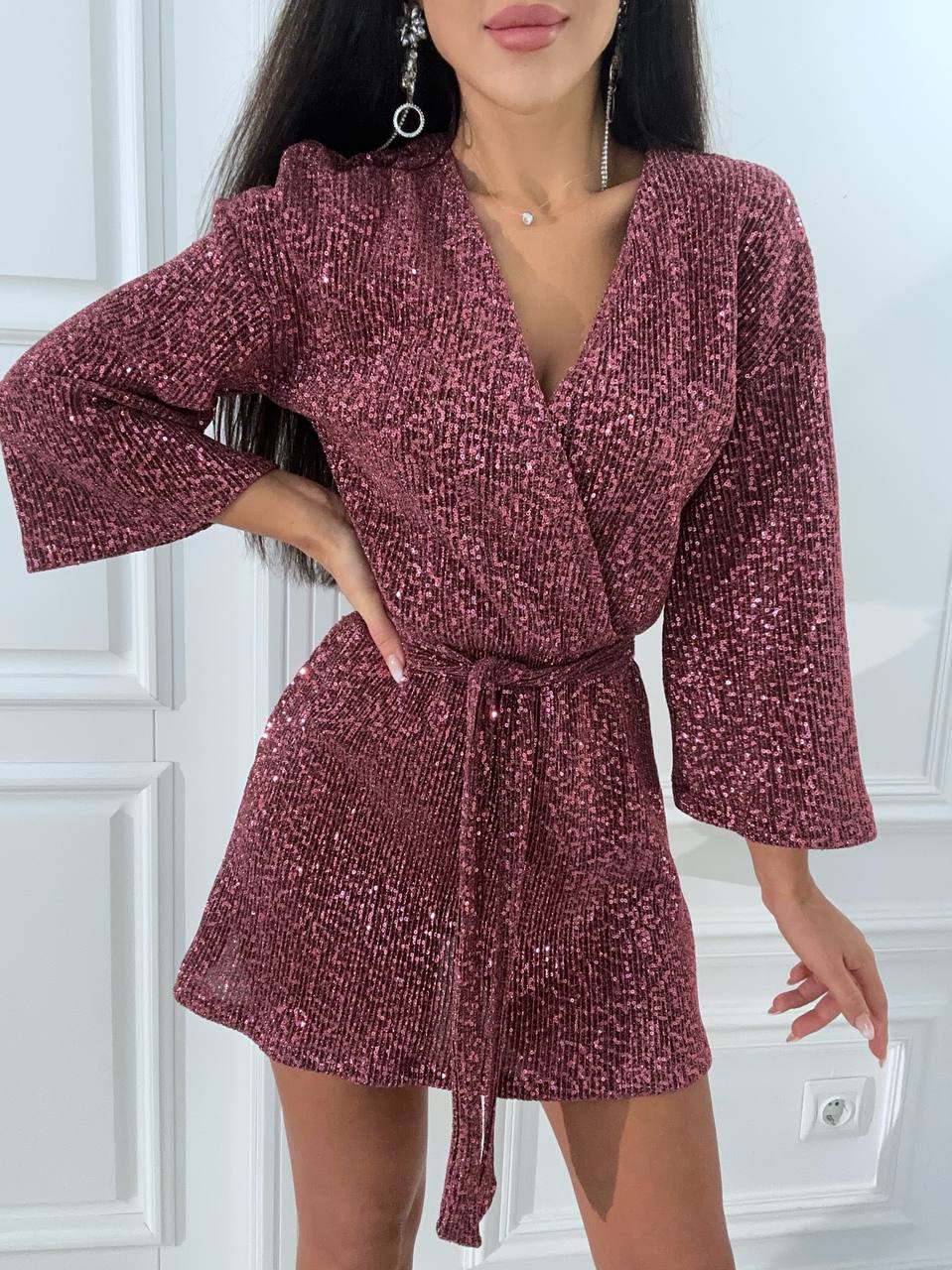 Woman wearing a burgundy textured dress with a white background