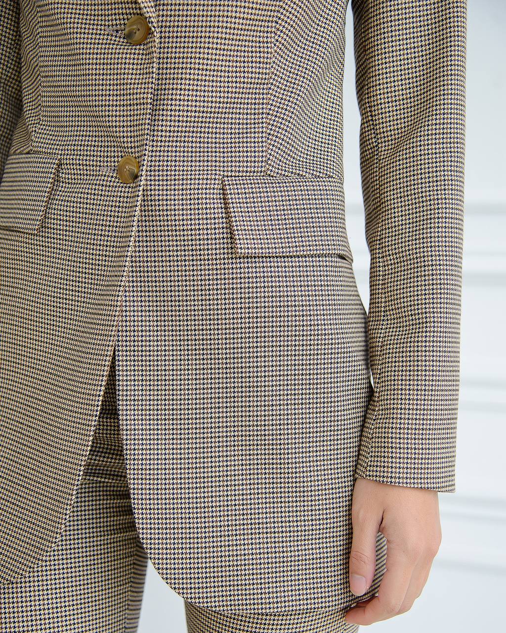 Houndstooth patterned suit jacket and pants on a white background