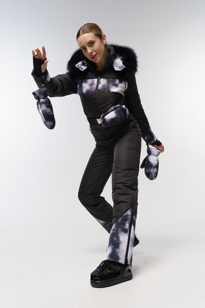 Person wearing a black and gray outfit with fur trim on a white background