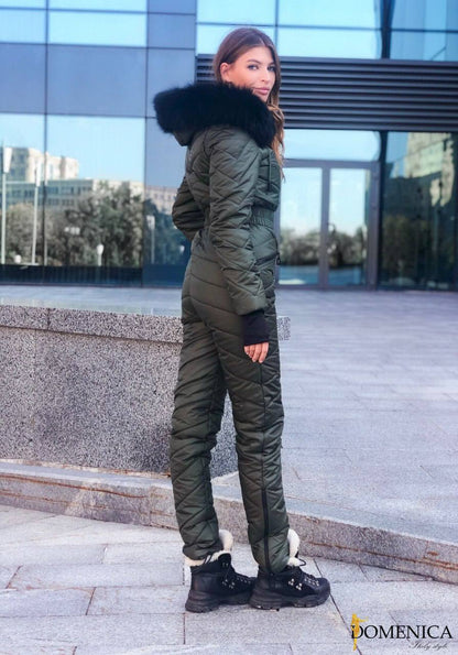 Woman wearing a green winter outfit with fur-lined hood in an urban setting