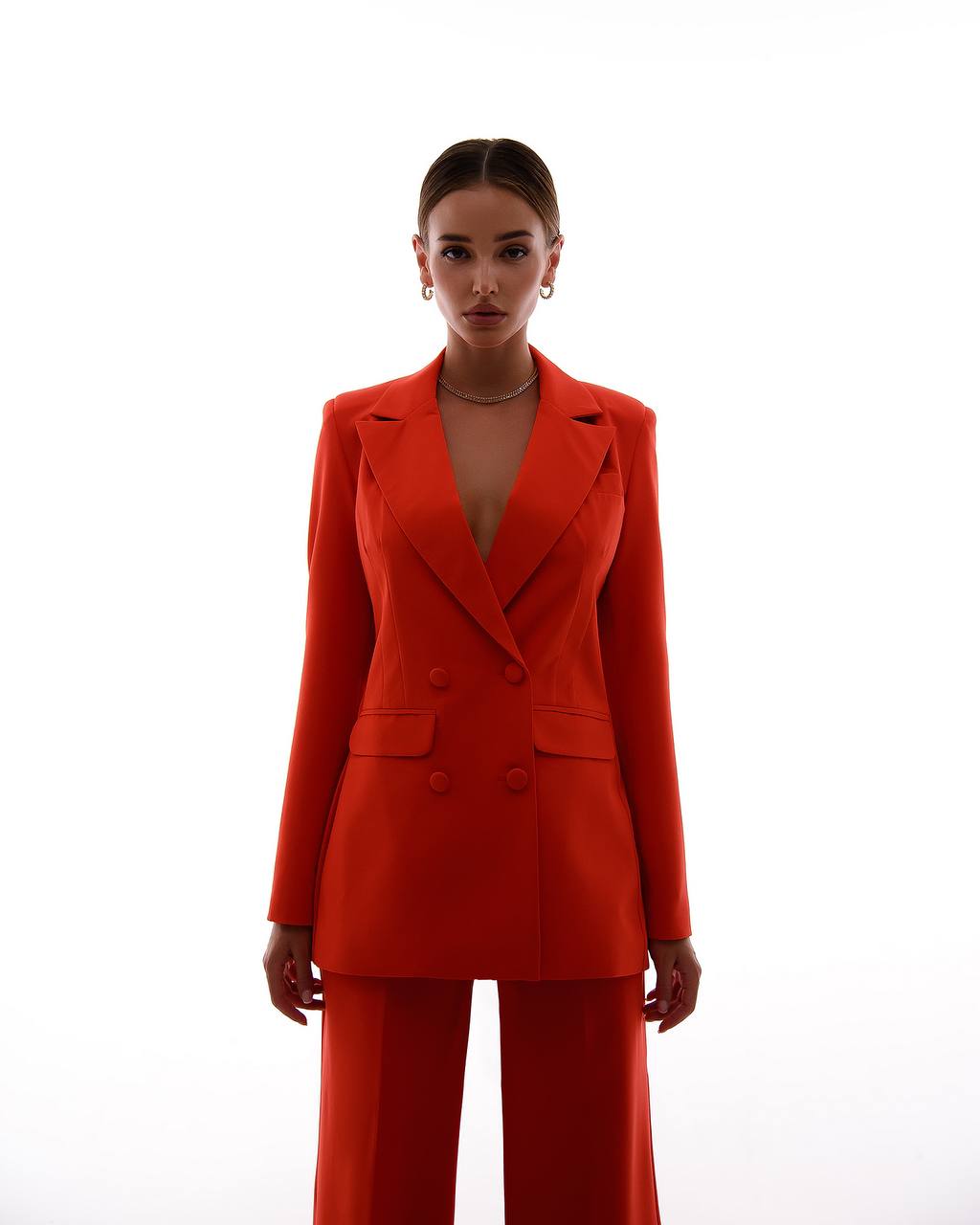 Woman wearing a red suit against a white background