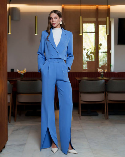Woman in a blue suit standing in an elegant interior setting