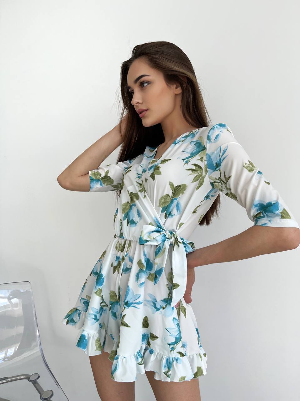 Woman wearing a floral dress against a white background