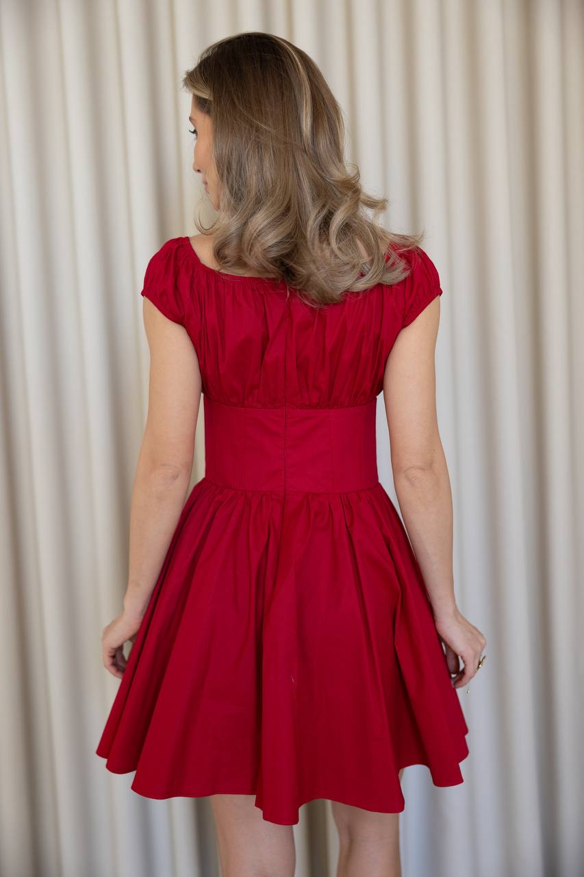 Woman wearing a red dress against a plain background
