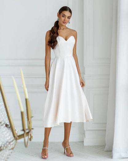 Woman wearing a white strapless dress in a minimalistic setting
