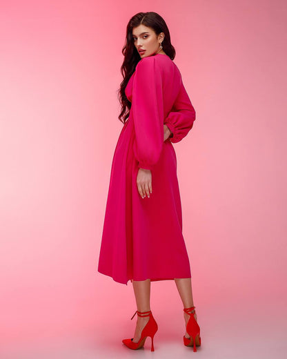 Woman wearing a bright pink dress against a pink background