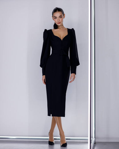 Woman wearing a black dress with puffed sleeves against a white background