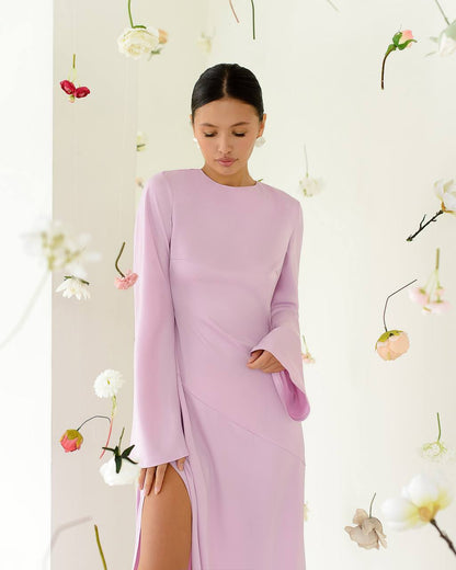 Woman wearing a light purple dress with floral decorations in the background