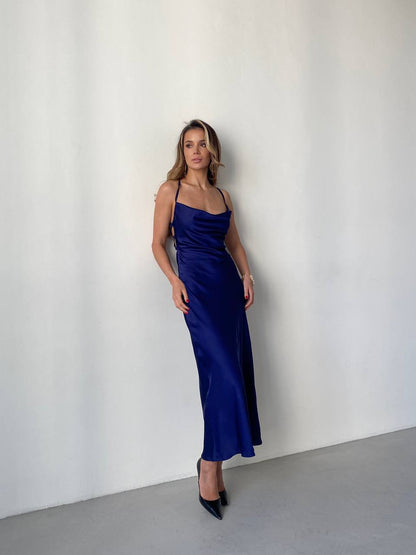 Woman wearing a blue satin dress against a white background