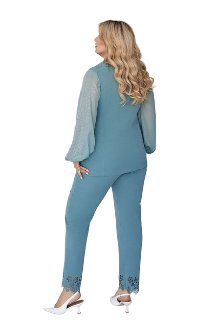 Woman wearing a teal outfit with a matching top and pants on a white background