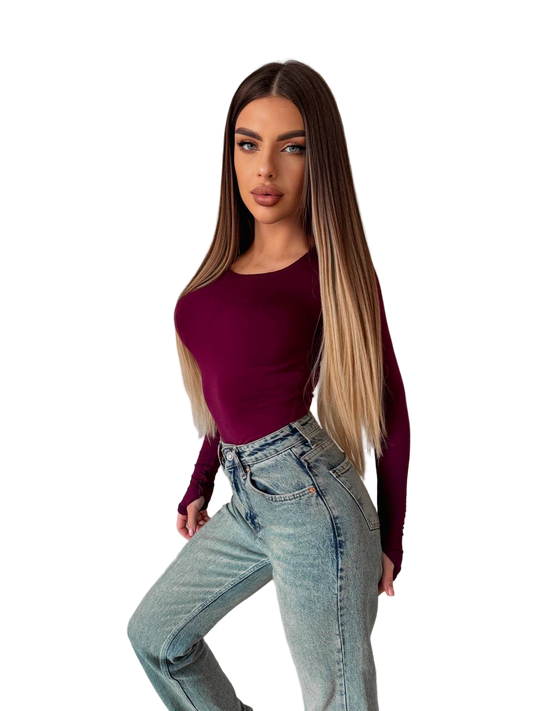 Woman wearing a maroon top and light blue jeans on a white background