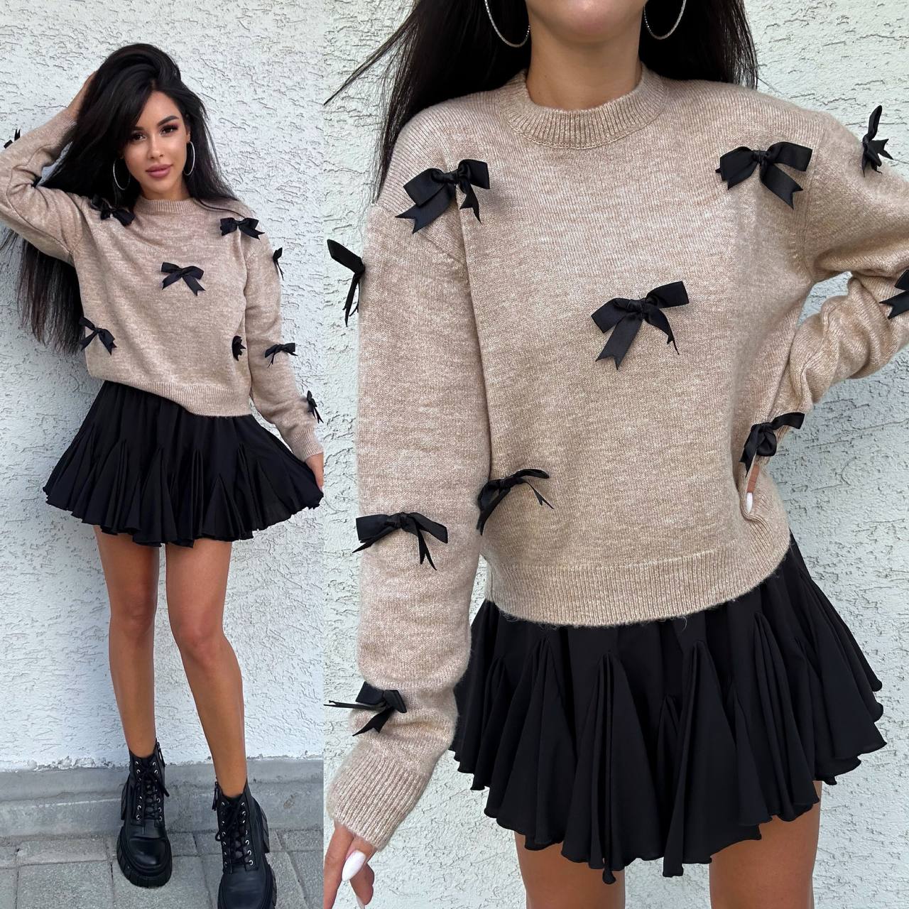 Woman wearing a beige sweater with black bows and a black skirt against a white wall.