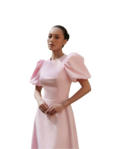 Woman wearing a pink dress with puffed sleeves on a white background