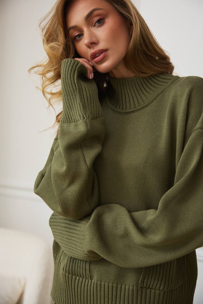 Woman wearing a green sweater against a white background