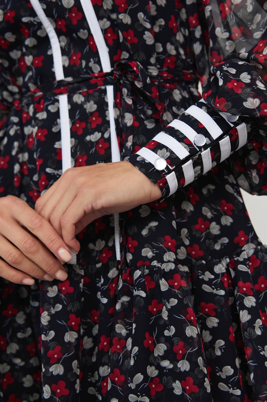 Close-up of a floral-patterned garment with a hood and striped cuffs.