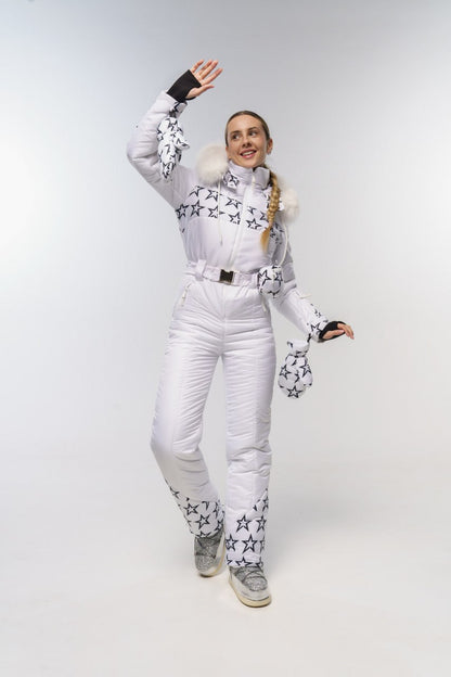 Person wearing a white snowsuit with star patterns on a plain background